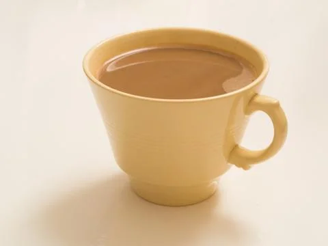 Cup of coffee in an angular yellow china cup Stock Photos