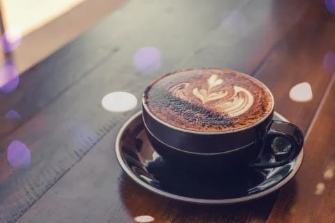 A cup of coffee with art on a table Stock Photos