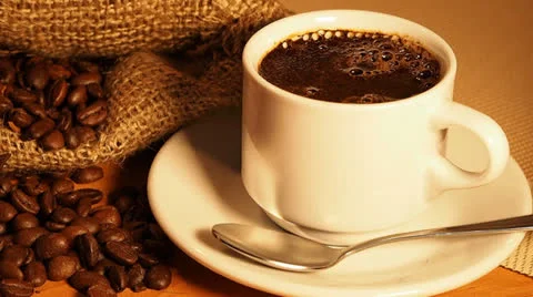 Cup of coffee on a background of a bag of coffee beans. Spoon coffee mixes Stock Footage 23136550