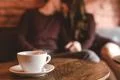 The cup of coffee on the background of the kissing couple Photo