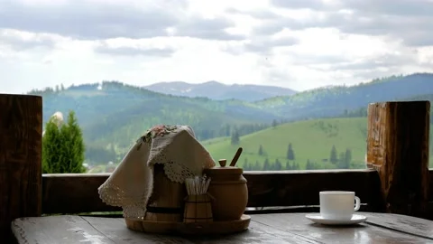 Cup of coffee on a background of mountains, hand lays sugar Stock Footage 130797129