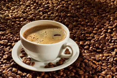Cup of coffee on a background of roasted beans Stock Photos