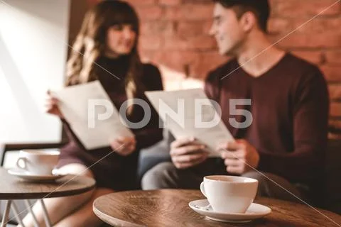 The cup of coffee on the background of the sitting couple Stock Photos