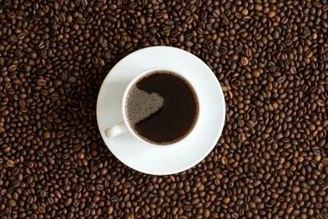 Cup of coffee on a beans background Stock Photos