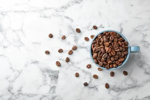Cup with coffee beans on marble background Foto stock