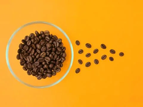 Cup with coffee beans on an orange background. Stock Photos