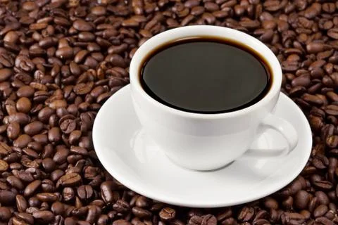 Cup of coffee on beans Stock Photos