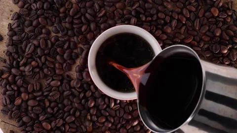Cup of Coffee With Beans. Pourring Black Coffee Video stock 132479247