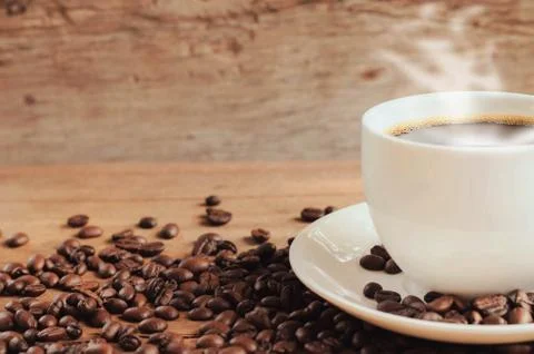 Cup of coffee with beans on table background Stock Photos
