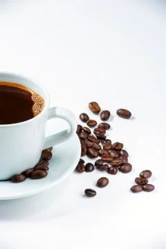 Cup of coffee with beans on white background. Stock Photos