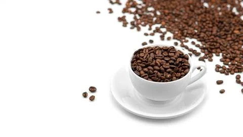 A Cup with coffee beans on a white background. Lots of coffee beans. Stock Photos