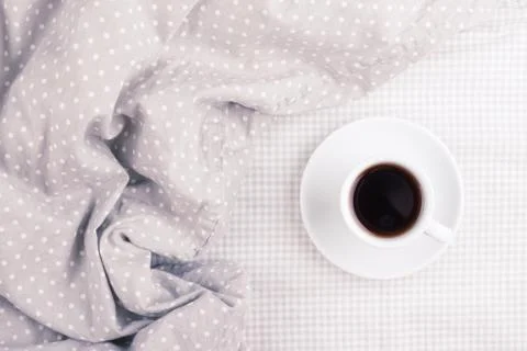 The cup of coffee on bed. Stock Photos