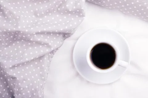 The cup of coffee on bed. Stock Photos