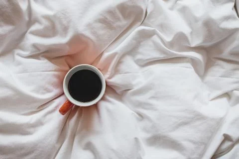 Cup of coffee on bed, top view Stock Photos