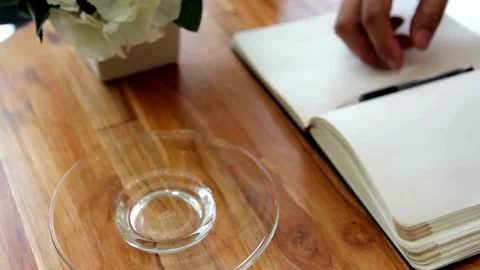 Cup of coffee being held by hands. Person drinking latte art coffee. 動画素材 334648739