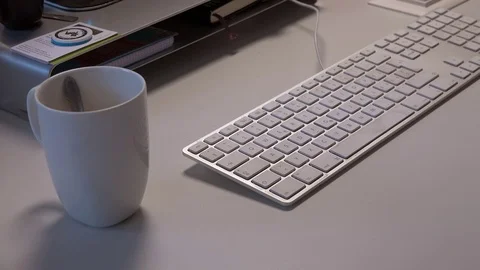 Cup of coffee being placed next to computer keyboard Stock Footage 71820703