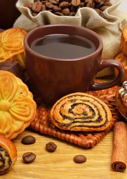 Cup of coffee with biscuits, coffee beans in bags and cinnamon sticks Stock Photos