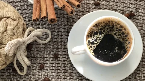 A cup of coffee black bubbles of hot steam fragrance. A close-up of a table of Stock Footage 76380375