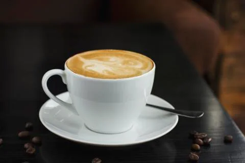 The cup of coffee on the black table in cafe Stock Photos