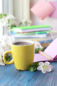 Cup of coffee, blank notebook for notes, a stack of books, apple flowers Stock Photos