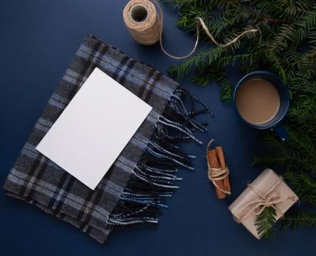 Cup of coffee on the blue table next to a scarf with a postcard Foto stock