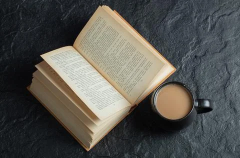 A cup of coffee with book on a dark background Stock Photos