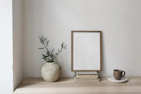 Cup of coffee, books. Empty vertical picture frame mockup on old books. Wooden Fotos Stock