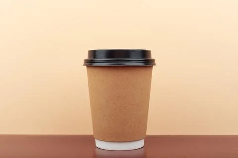 Cup of coffee on brown table against beige background with copy space Stock Photos
