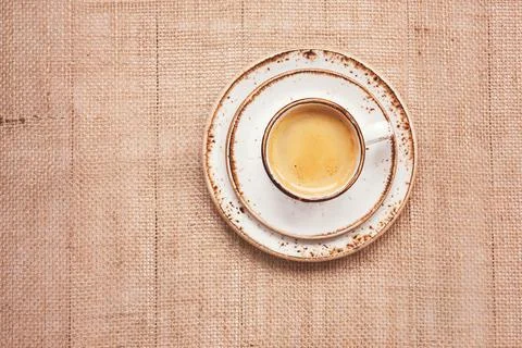 Cup of coffee on burlap background. Top view, toned, copy space Stock Photos