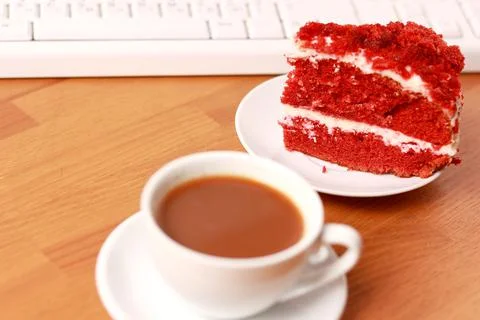 A cup of coffee, cake and a computer keyboard. Foto stock