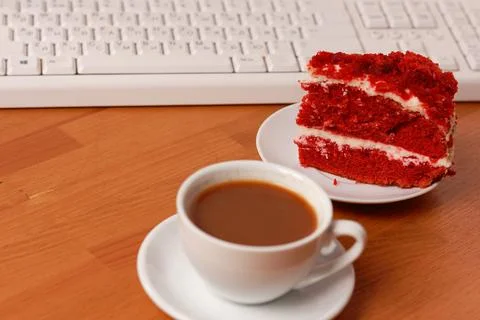 A cup of coffee, cake and a computer keyboard. Stock Photos