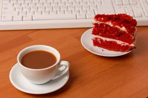 A cup of coffee, cake and a computer keyboard. Stock Photos