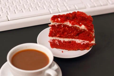 A cup of coffee, cake and a computer keyboard. Stock Photos