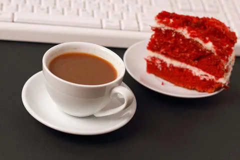 A cup of coffee, cake and a computer keyboard. Stock Photos