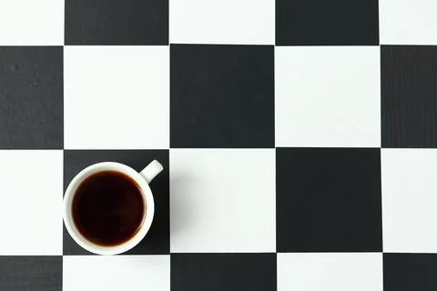 A cup of coffee on a chessboard. Stock Photos