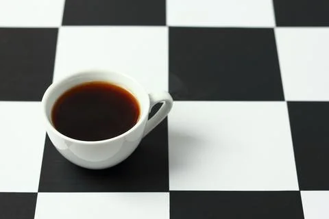 A cup of coffee on a chessboard. 스톡 사진