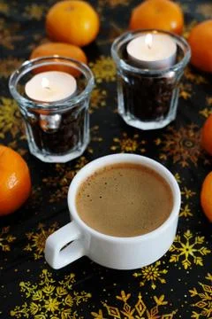 Cup of coffee on christmas pattern background. Mandarines and coffee candles in Stock Photos