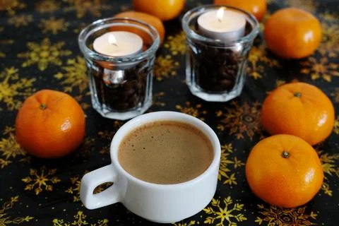Cup of coffee on christmas pattern background. Mandarines and coffee candles in Stock Photos
