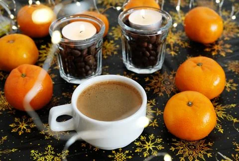 Cup of coffee on christmas pattern background. Mandarines and coffee candles in Stock Photos