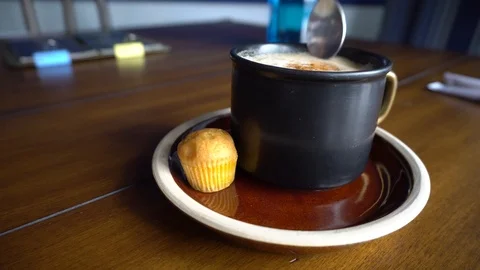 Cup of coffee with cinnamon on plate with cake. Stirring sugar with spoon. Stock Footage 88724629