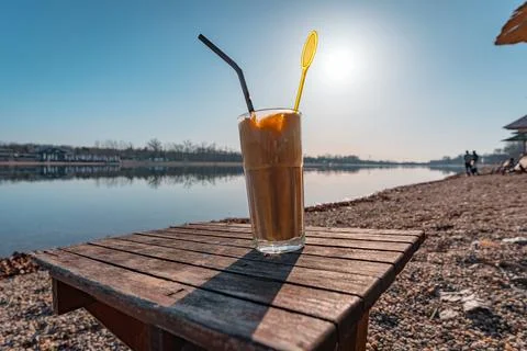 A cup of coffee close-up against the backdrop of the lake Stock Photos