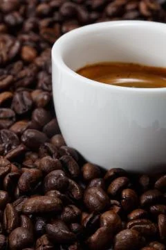 A cup of coffee with coffee bean as background Stock Photos