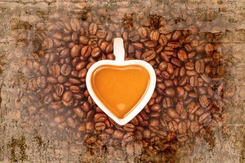 A cup of coffee with coffee bean on old wall textured background. retro filte Stock Photos