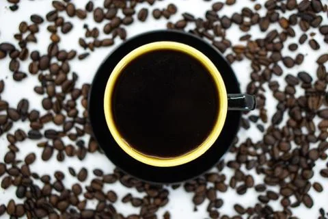 A cup of coffee on coffee beans background. Selective focus. Stock Photos