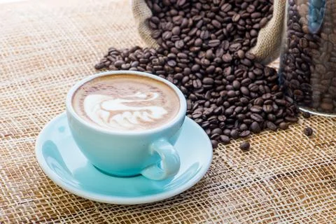 Cup of coffee on coffee beans background on a wooden table Stock Photos