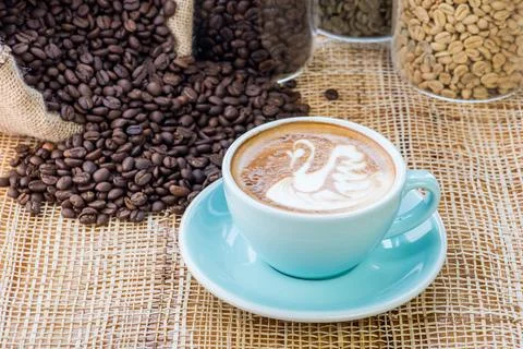 Cup of coffee on coffee beans background on a wooden table Stock Photos