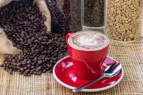 Cup of coffee on coffee beans background on a wooden table Stock Photos