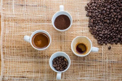 Cup of coffee on coffee beans background on a wooden table Stock Photos