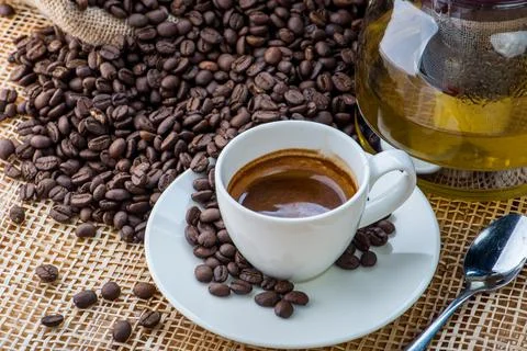 Cup of coffee on coffee beans background on a wooden table Stock Photos