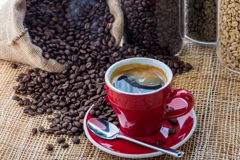 Cup of coffee on coffee beans background on a wooden table Stock Photos
